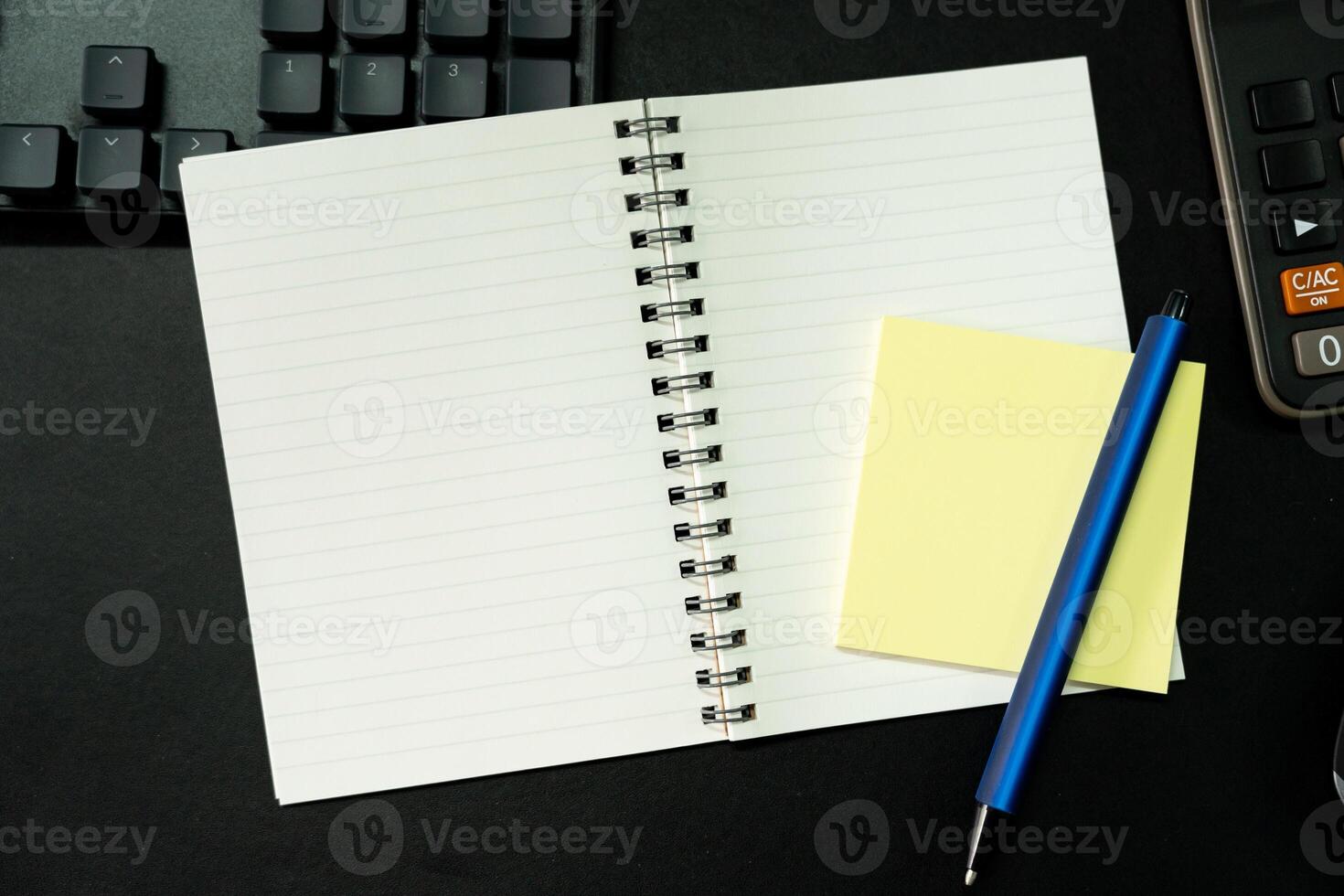 Top view of notebook. Blank paper notepad on office desk table with keyboard and other supplies. Blank notebook page for input the text. copy space, flat lay. photo