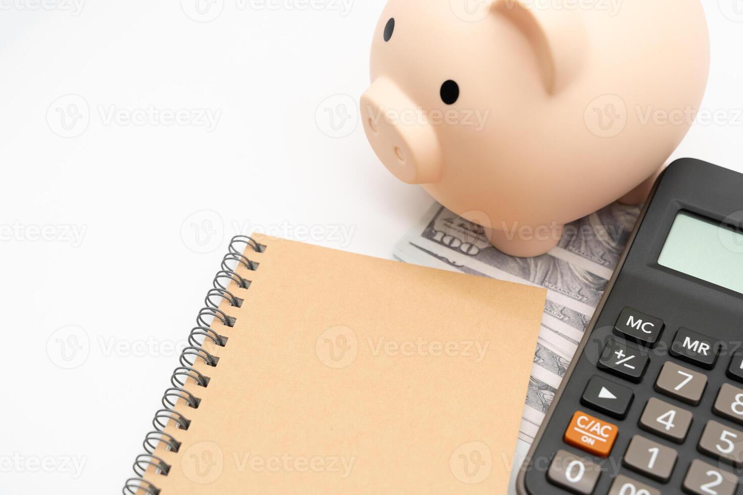 Piggy bank, Notebook with calculator isolated on white background, financial goal, money saving concept with copy space. Budget planning concept. photo