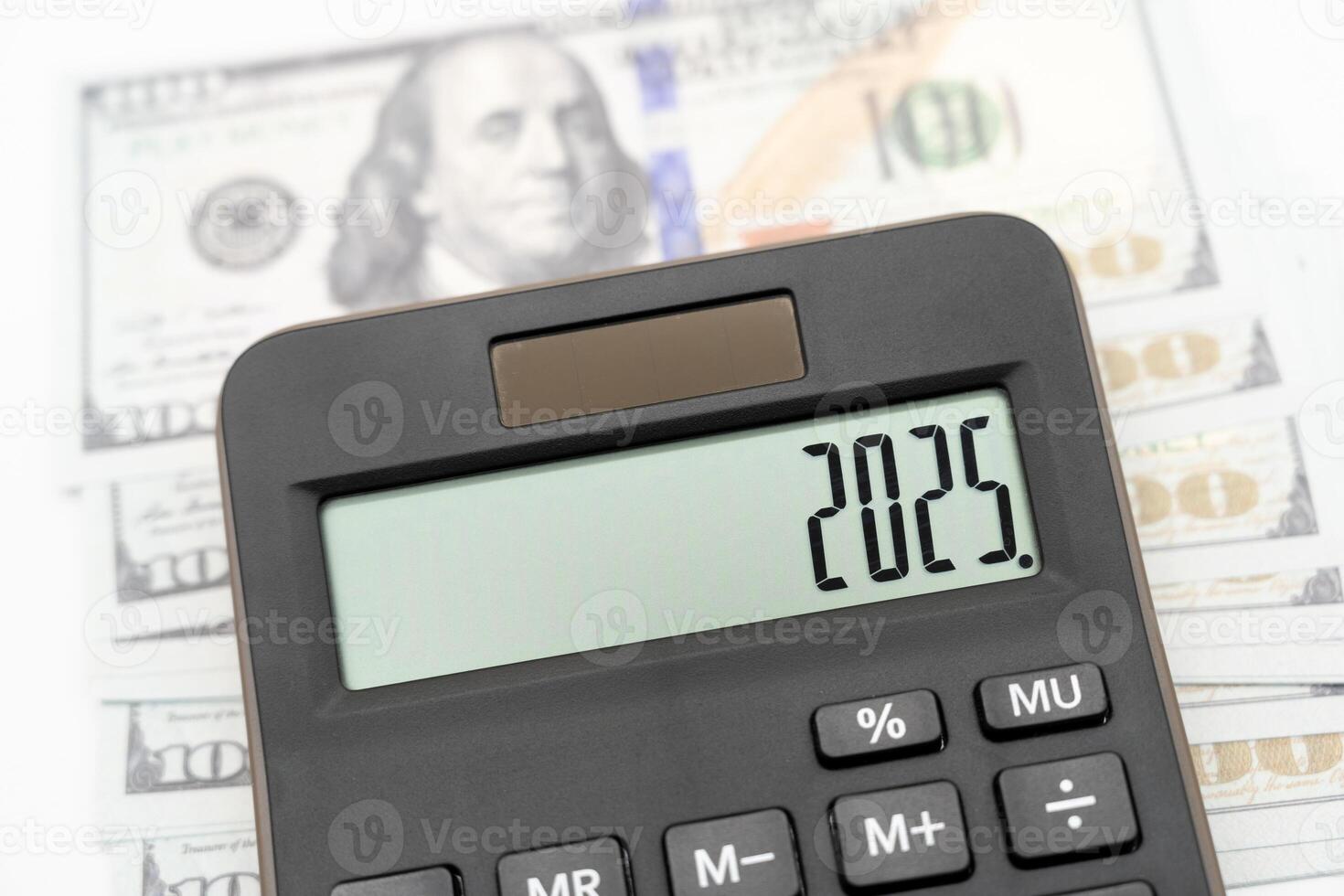 US Dollar banknotes, calculator and forecast for finances in 2025. Money, Budget, tax, investment, financial, savings and New Year Resolution concepts. calculator with 2025 numbers. photo