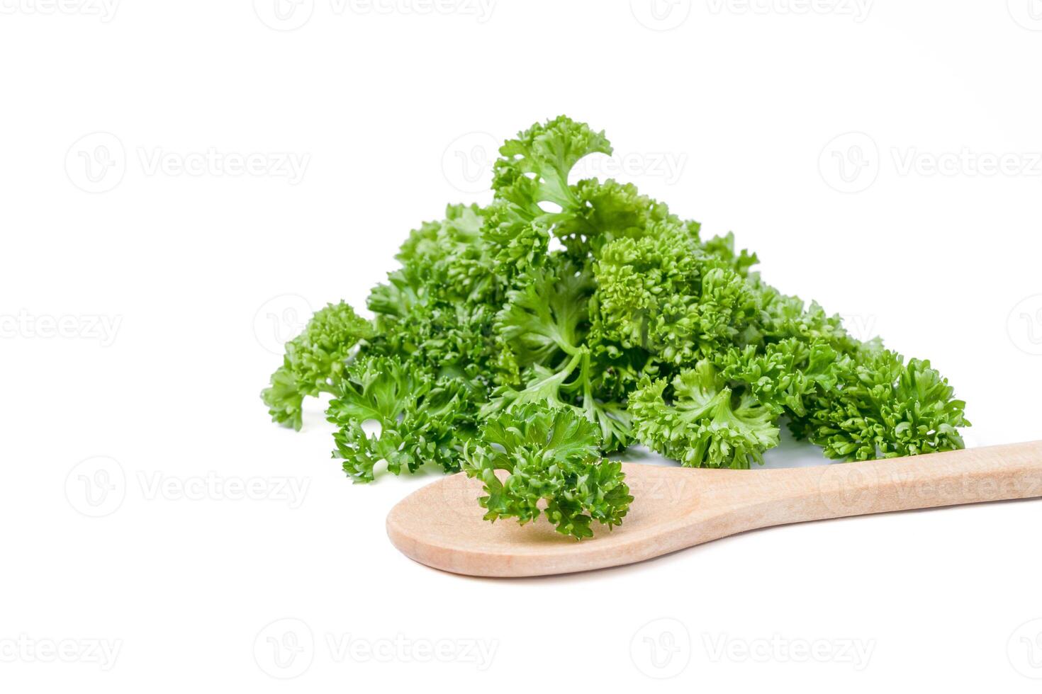 Fresh chopped parsley leaves in wooden spoon on white background. photo