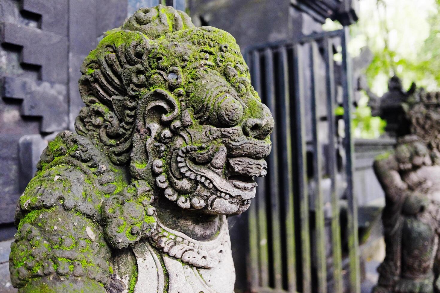 lichen growing on ancient lion stucco statue is god and belief in Hindu with religion and culture decorated outdoor fornt arched entrance gate and facade in a Hindu temple on Bali Island of Indonesia photo