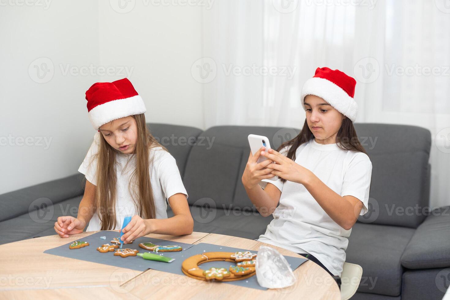 Two girls sisters are playing around in the kitchen after making Christmas cookies, they draw with flour on the table and on their faces. Christmas, New Year concept photo