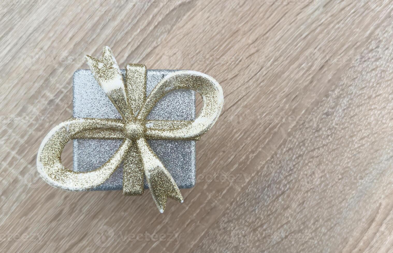 Black gift box on a background, decorated with a textured bow and feathers, creating a romantic atmosphere. Typically used for birthday, anniversary presents, gift cards, post cards. photo