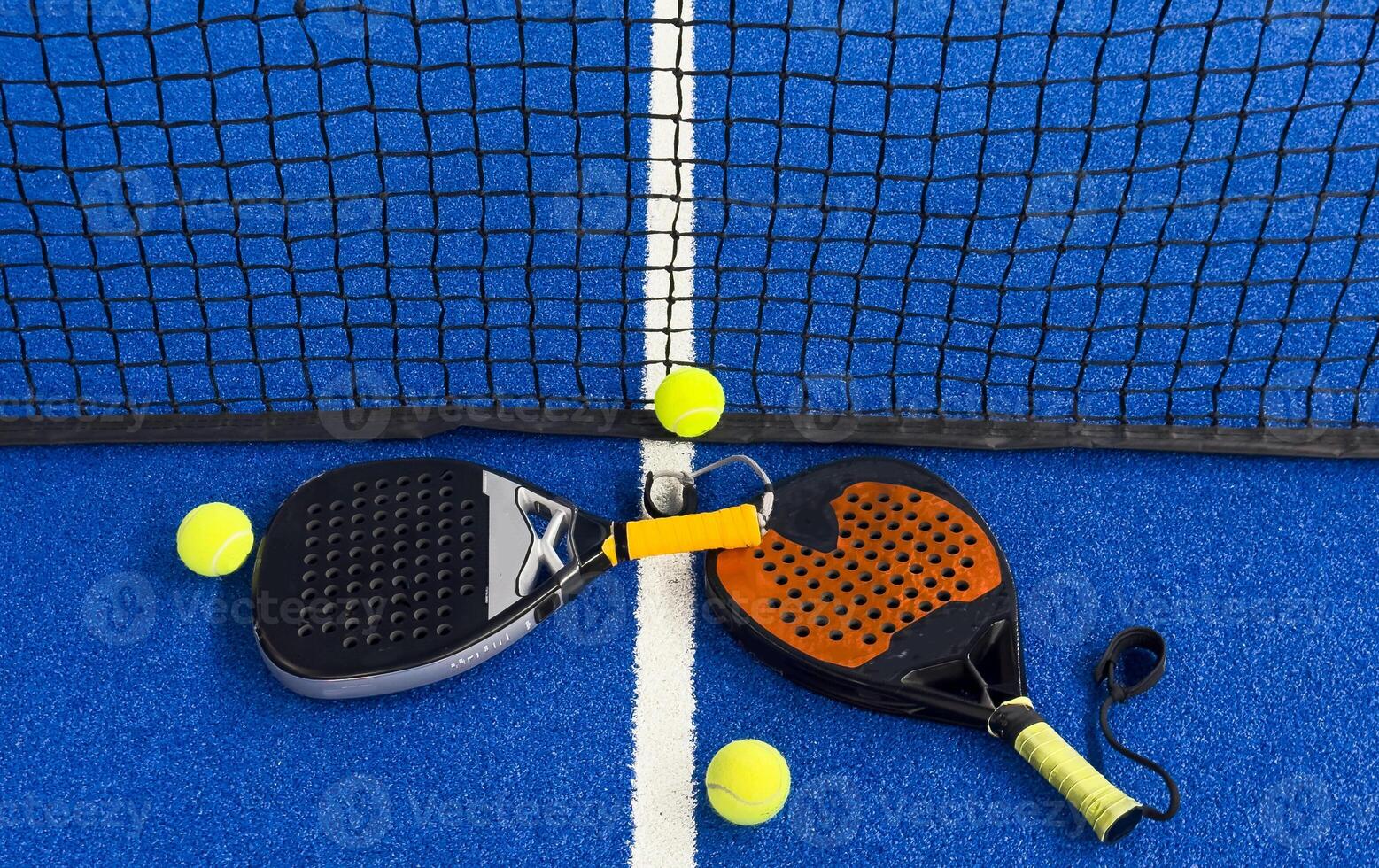padel racket on a padel blue court with a ball photo