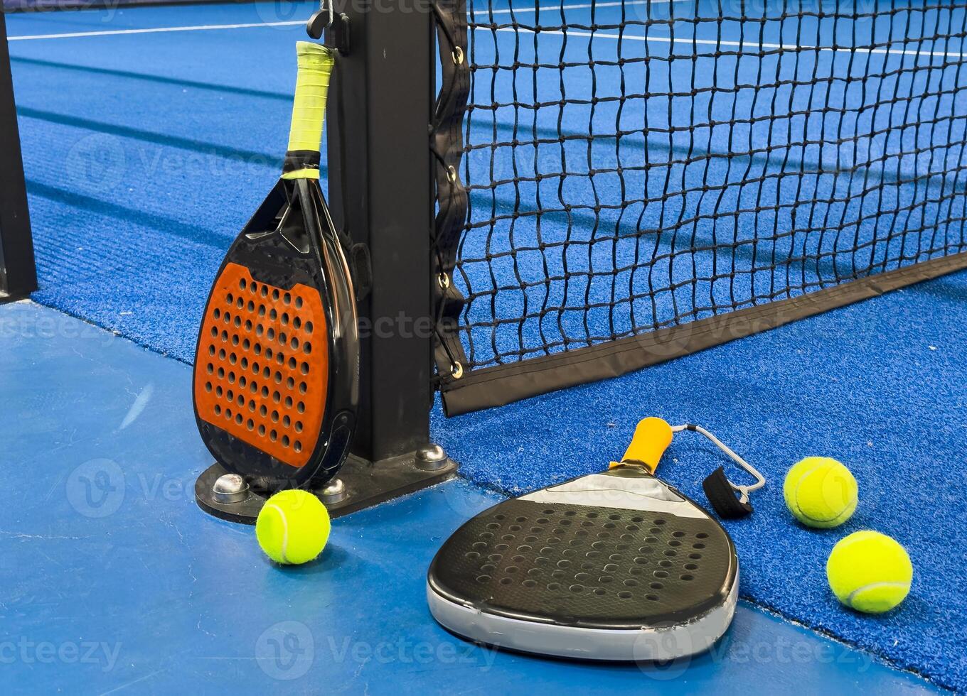 Black professional paddle tennis racket and ball with natural lighting on blue background. Horizontal sport theme poster, greeting cards, headers, website and app photo