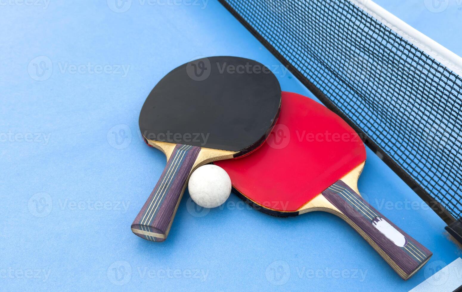 table tennis or ping pong racket and balls on a blue table photo