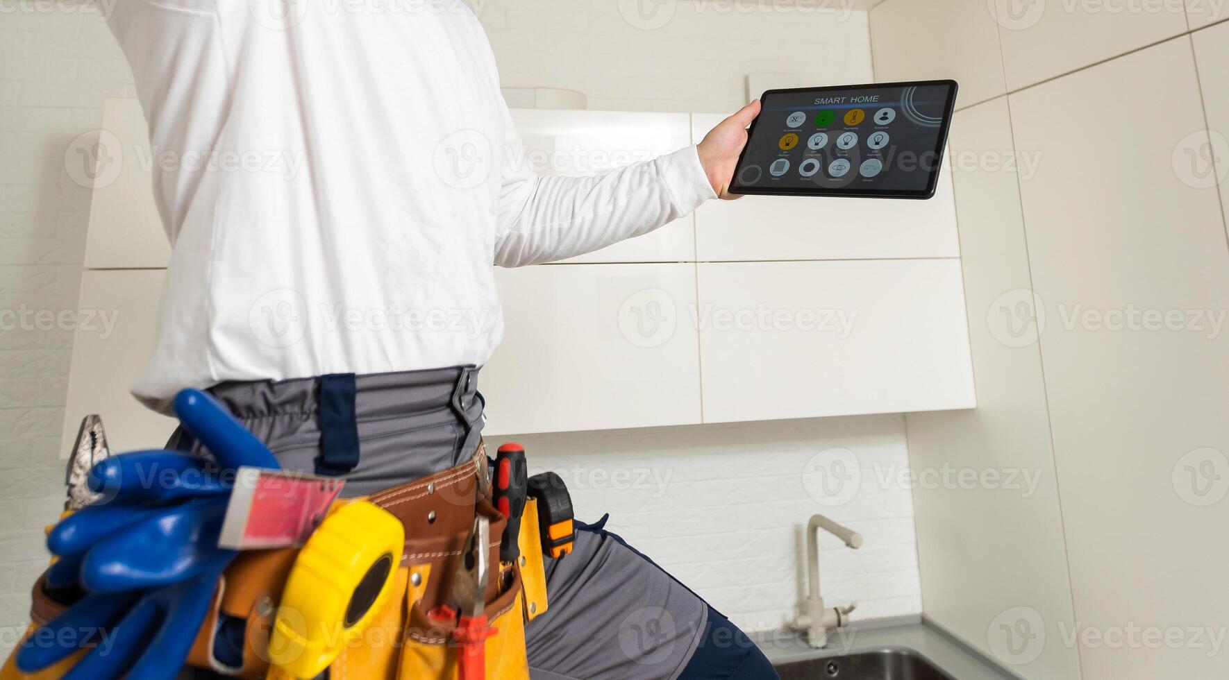 A worker looks at a tablet computer. Master with an electronic tablet in his hands photo