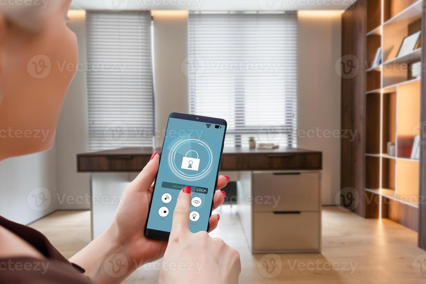 Smart home automation app on smartphone hold by female hand with home interior in background photo