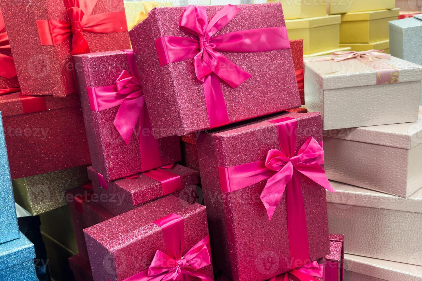 Boxed gift in glittery paper on grey background holidays concept. photo
