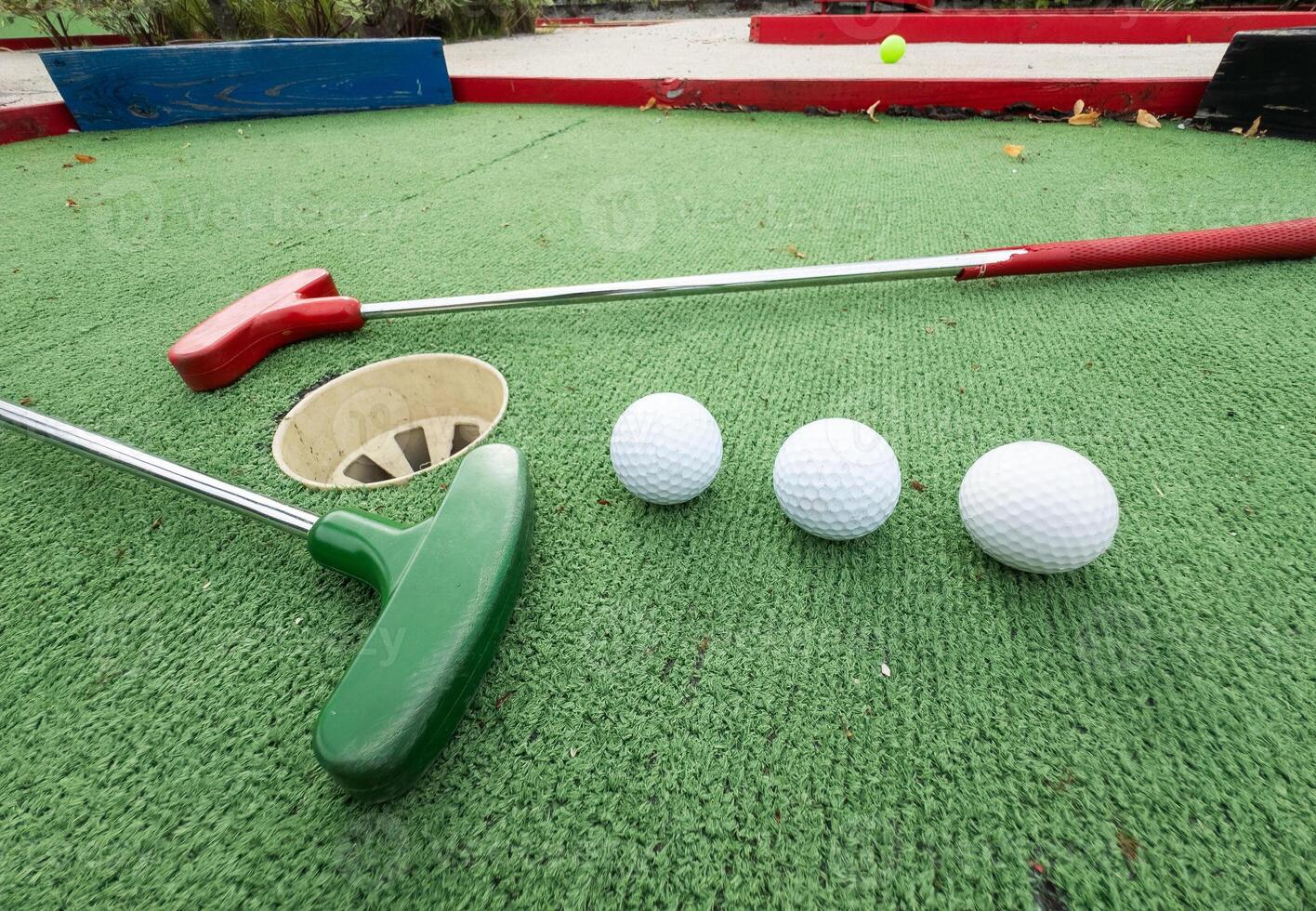 Fun vacation entertainment for summertime. Playing mini golf on green grass outdoors. Setting goals and winning lifestyle concept. Competition at golf course. two crossed sticks. Blank space for copy. photo