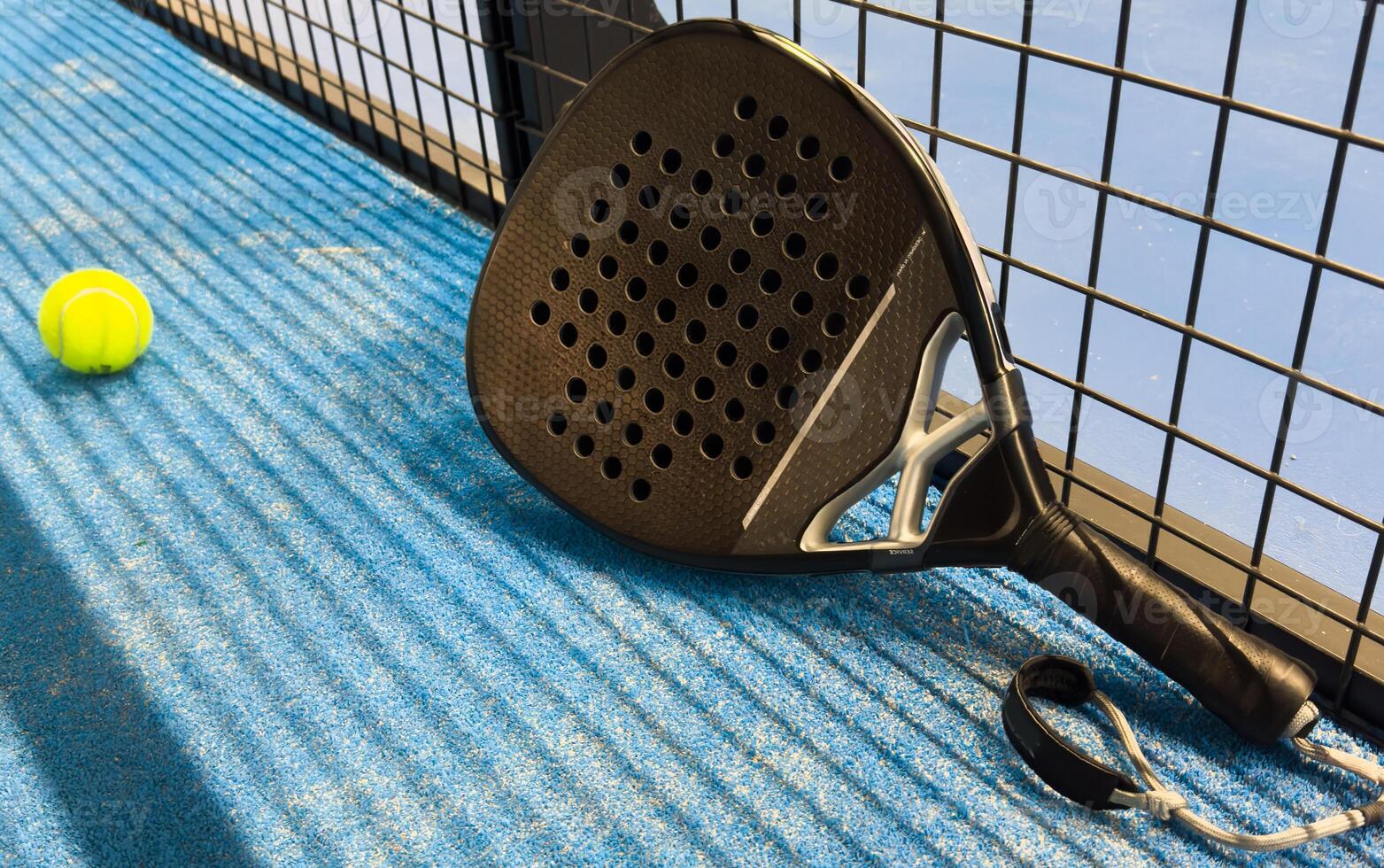 Paddle racket with a ball. Padel court in summer. photo