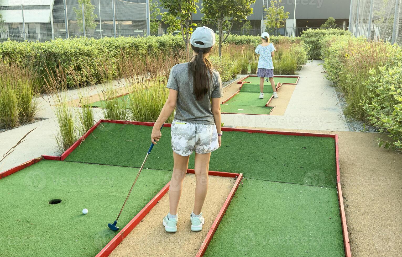 children practice playing mini golf photo