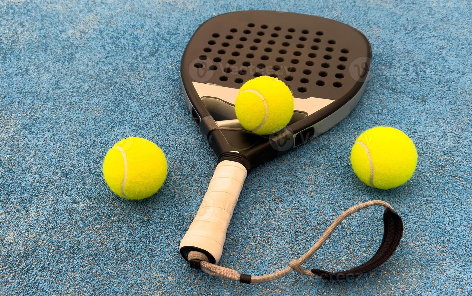 view from above of a green paddle racket and a ball on a blue synthetic paddle tennis court photo