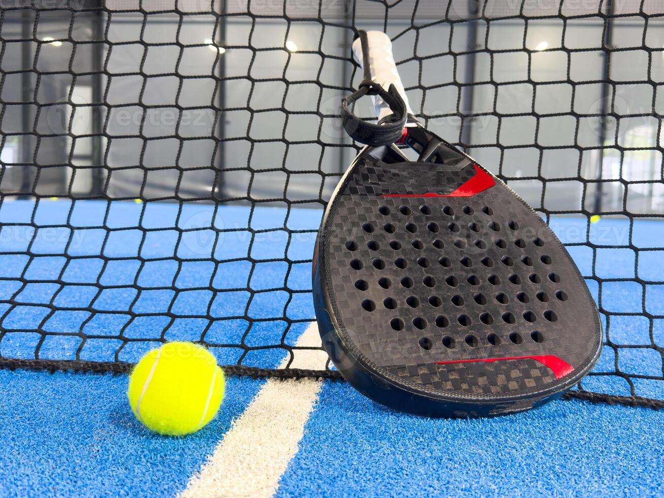 padel racket on a padel blue court with a ball photo