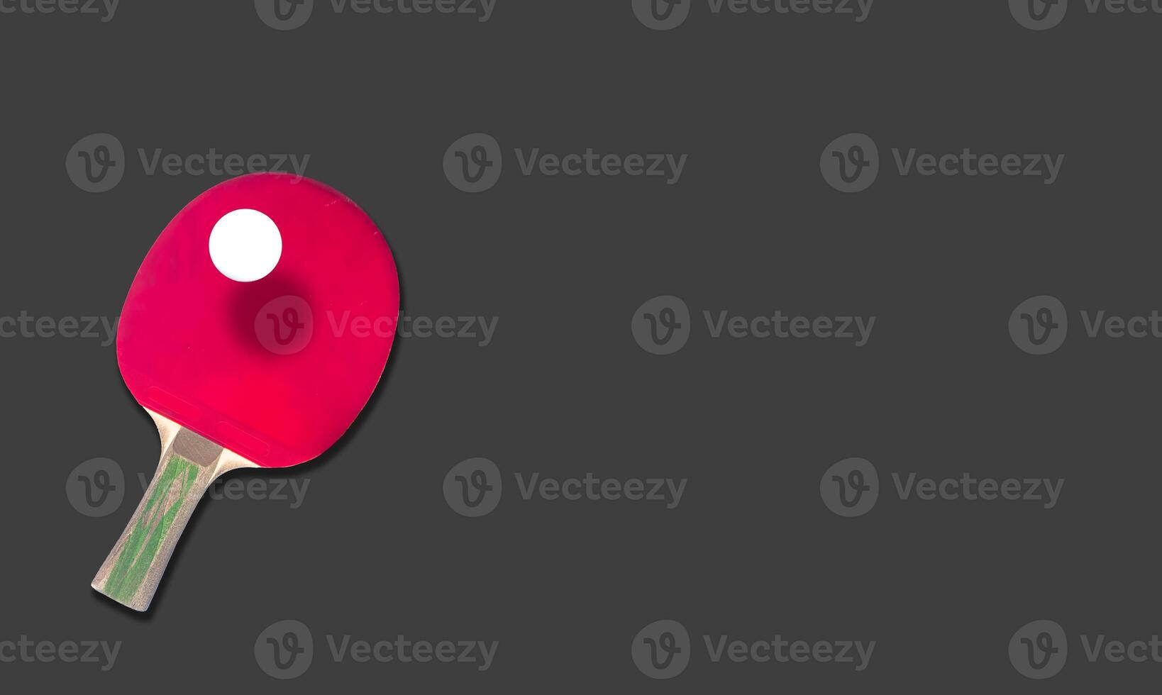 Red table tennis racket with a ball isolated on a colored background. sport equipment for ping pong. copy space photo