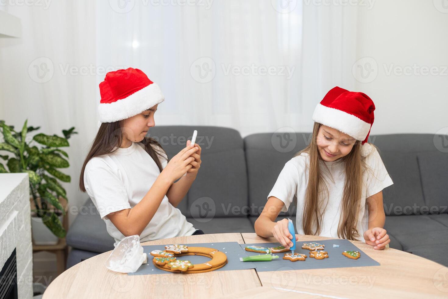 Two girls sisters are playing around in the kitchen after making Christmas cookies, they draw with flour on the table and on their faces. Christmas, New Year concept photo