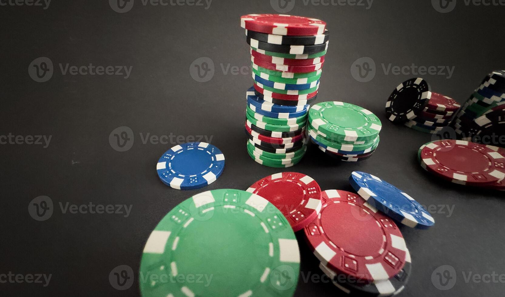 Colorful different value poker chips on black casino table, win after game. Concept of hazard gaming photo