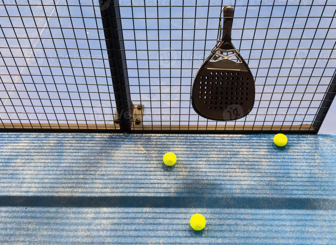 Paddle racket with a ball. Padel court in summer. photo