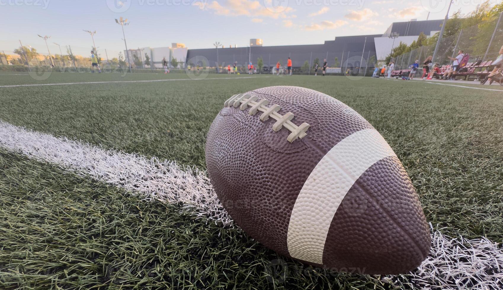 American football resting on a first down line during an American football game. The ball is ready to be snapped to start a new play. Lots of copy space photo