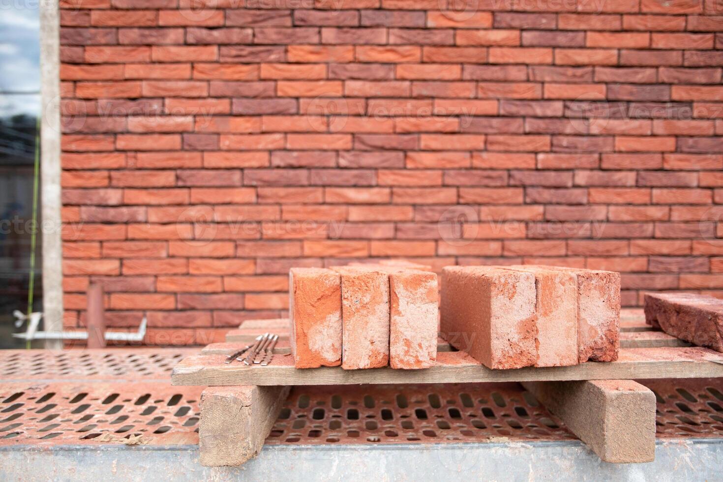 a new House is being built, the beginning of brickwork with red bricks, building materials, a pattern of stones, a natural background. High quality photo