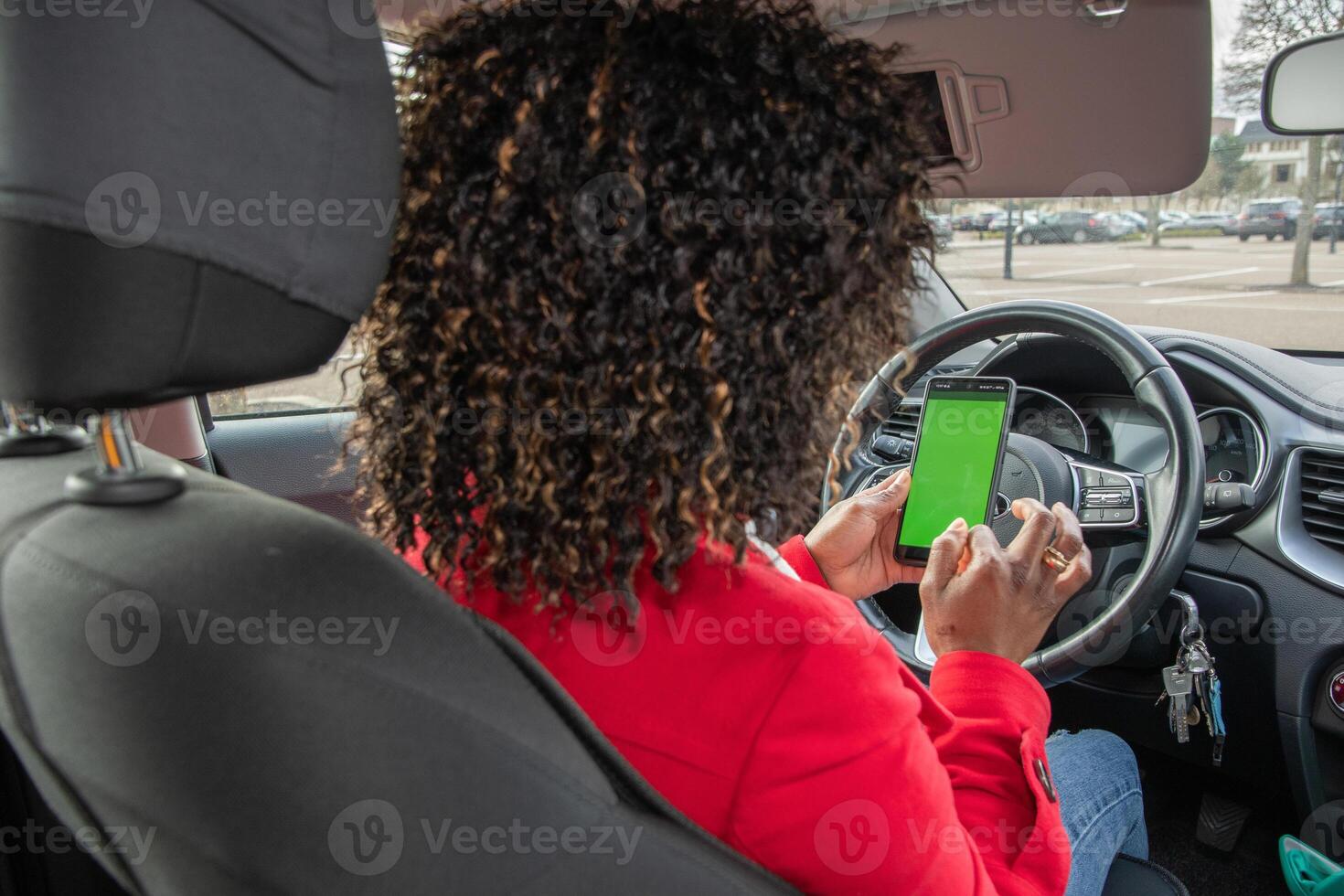 Satisfied young african american woman chatting in car with someone on mobile phone with green screen in parked car, using technology, High quality photo