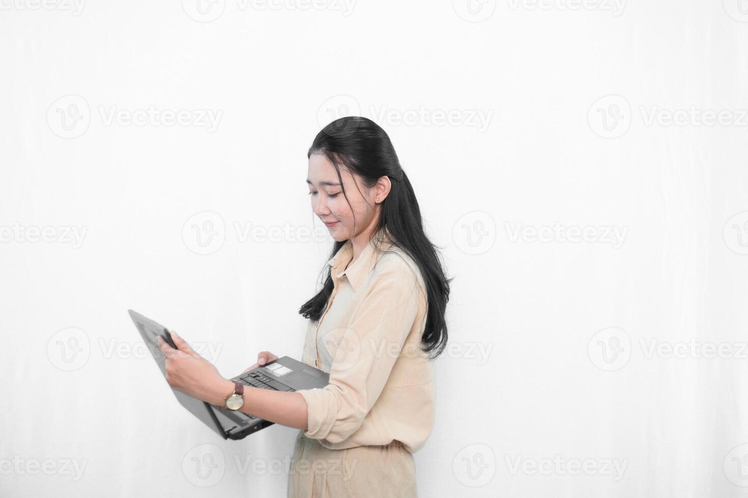 Expression of an Indonesian Asian model woman in white using a laptop photo