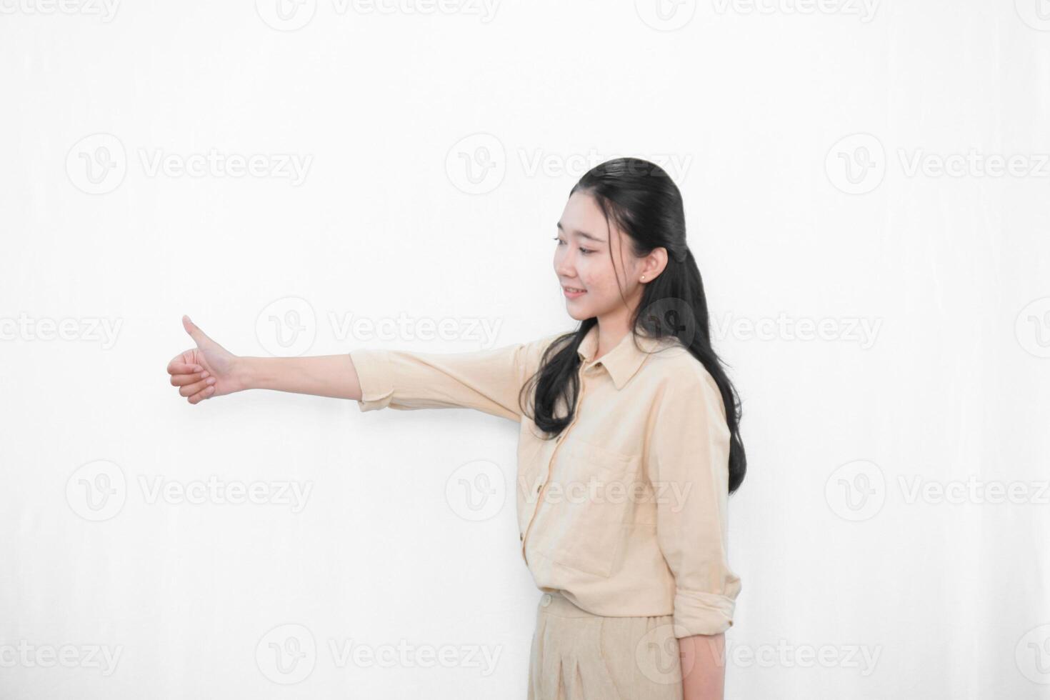 Expression of Indonesian Asian model woman in white dress smiling and giving thumbs up photo