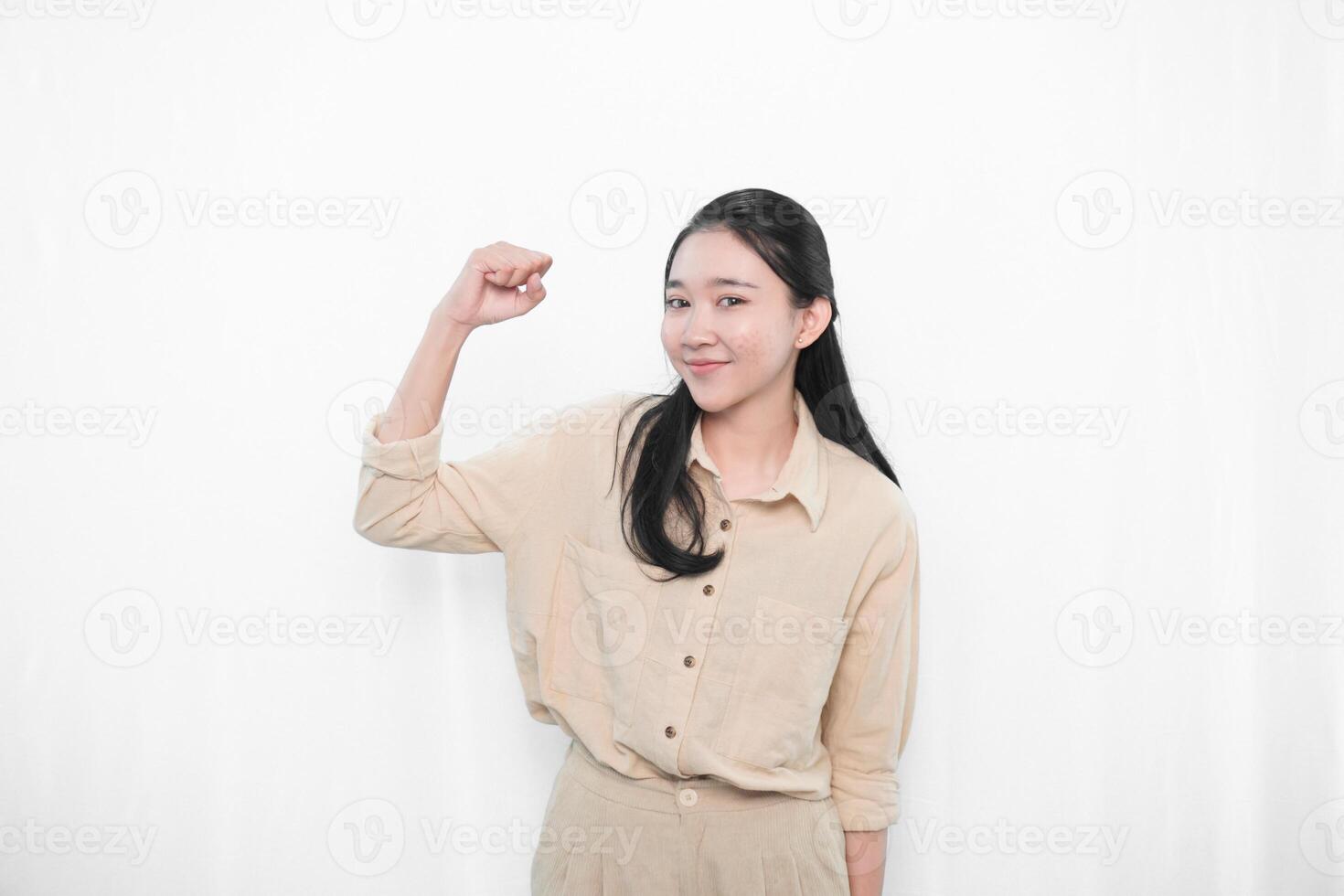 The expression of an Indonesian Asian model woman in white is smiling and making a code of encouragement photo