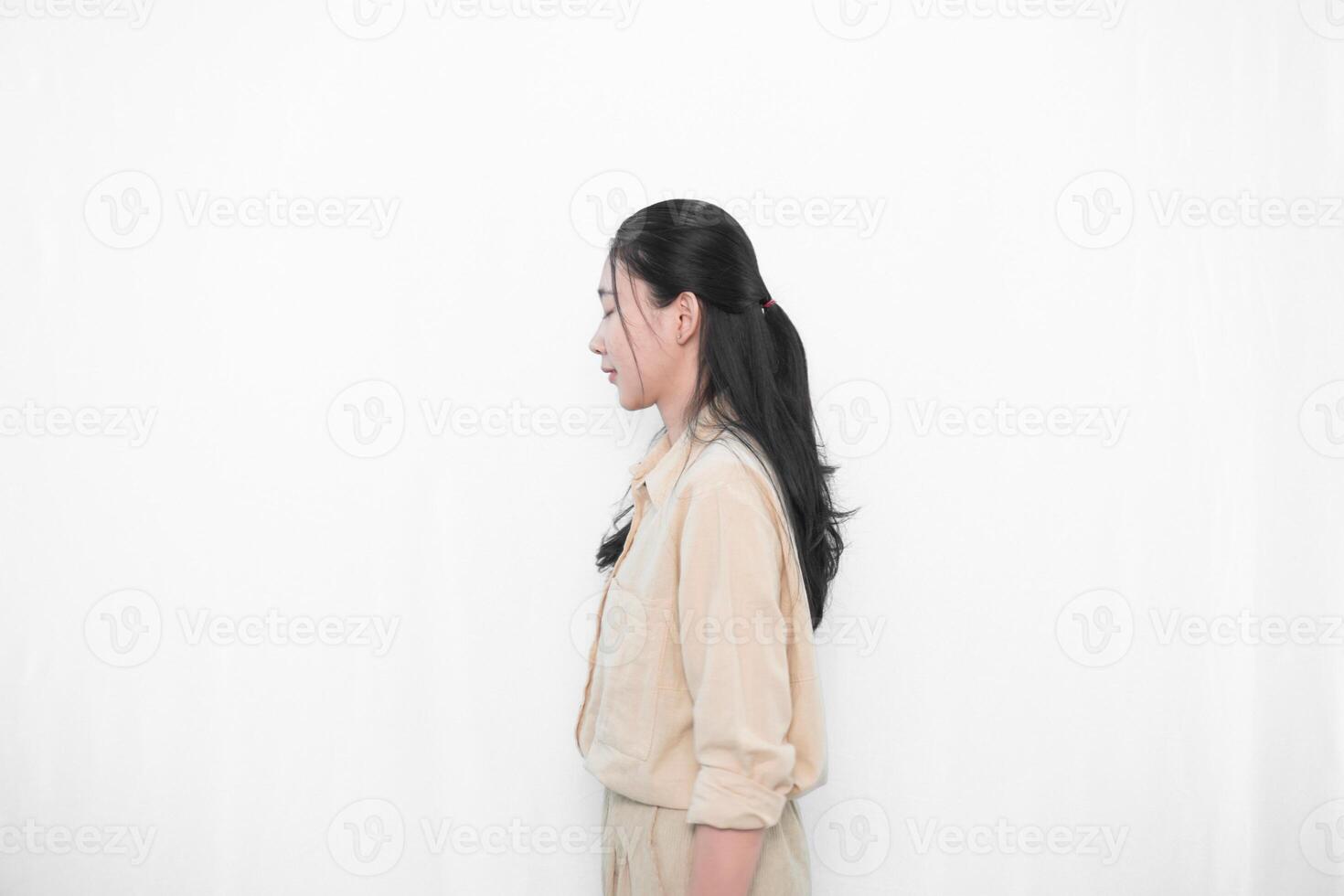 Expression of Indonesian Asian model woman in white dress smiling and standing straight photo