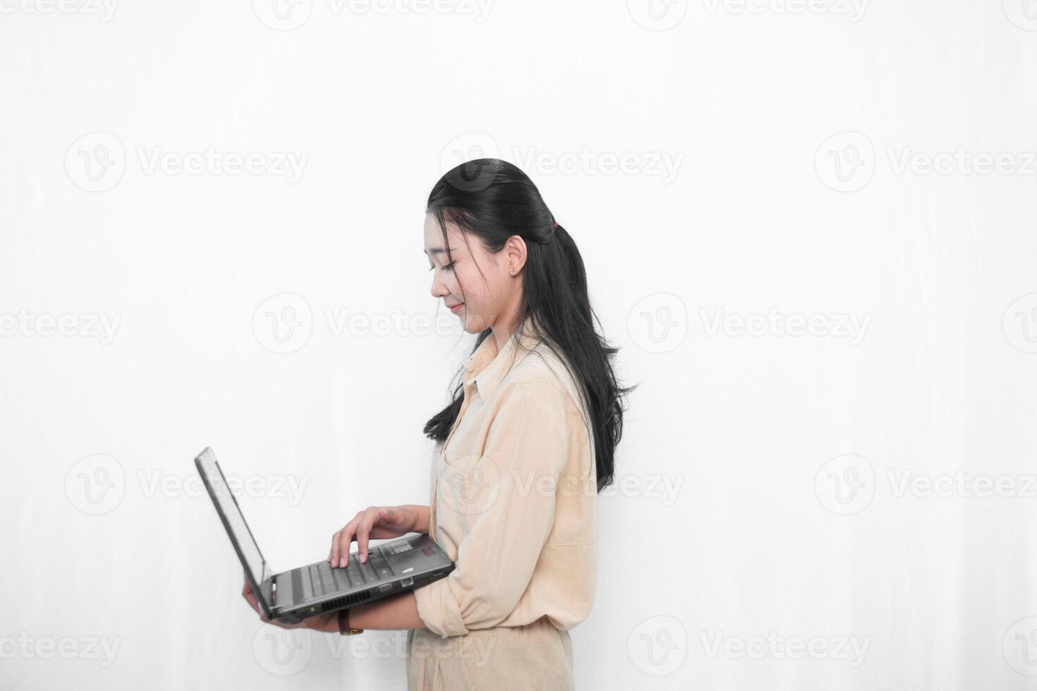 Expression of an Indonesian Asian model woman in white using a laptop photo