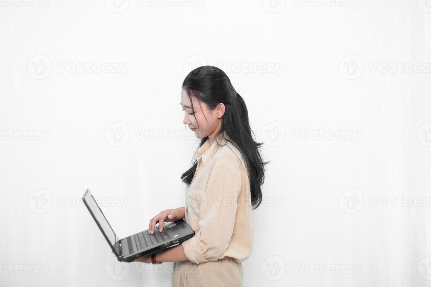 Expression of an Indonesian Asian model woman in white using a laptop photo