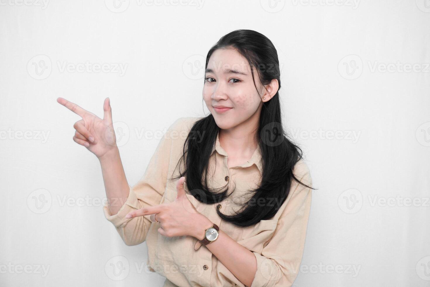 Expression of Indonesian Asian model woman in white dress smiling and making gun sign photo