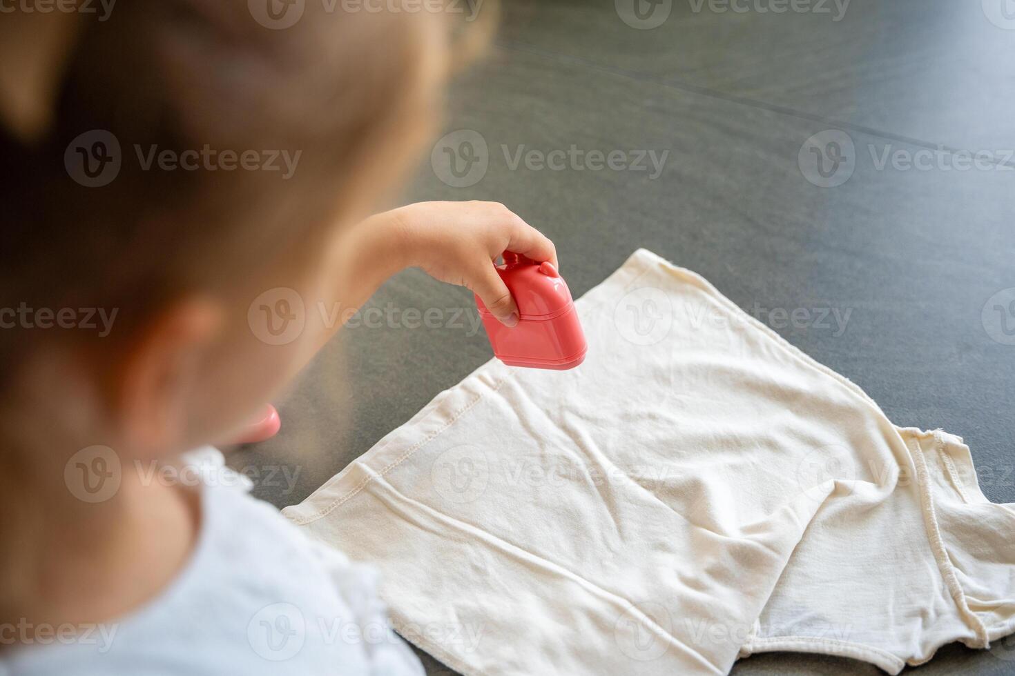 Back view of little girl with a stamp with a name for signing children's things. Identification of personal clothing. High quality photo