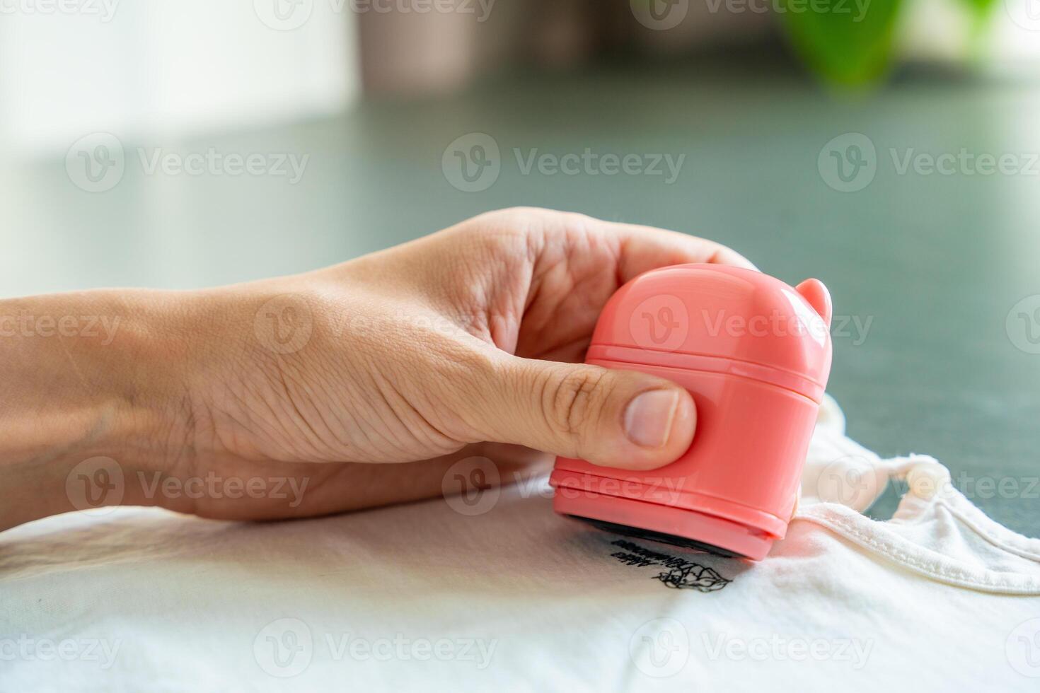 Close-up view of woman's hands with a stamp with a name for signing children's things. Identification of personal clothing. High quality photo