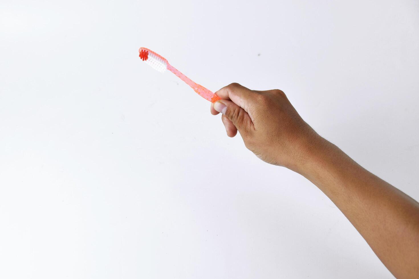 a man's hand holding a toothbrush on a white background photo