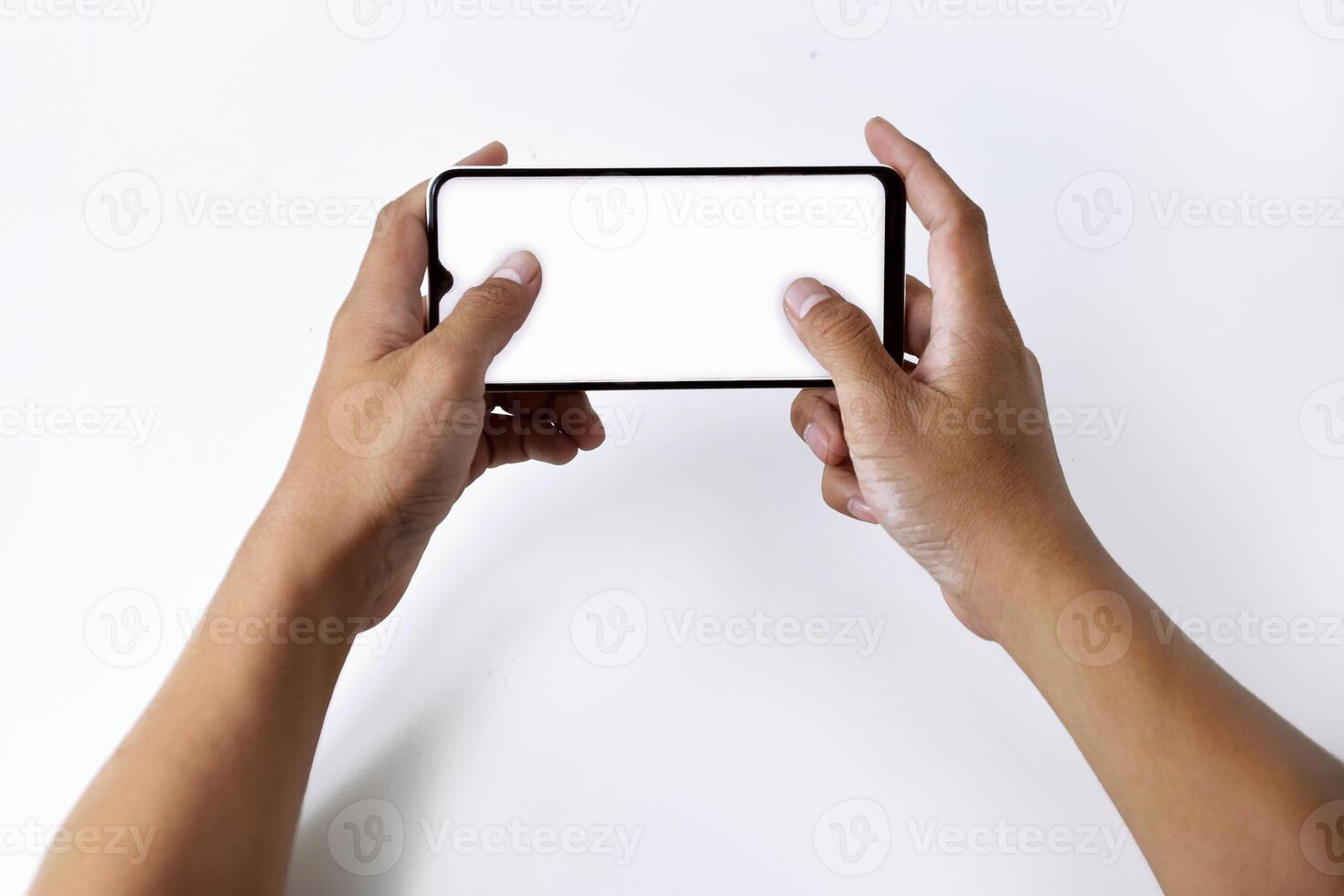 A man's hand is playing with a mobile smartphone with a white screen photo