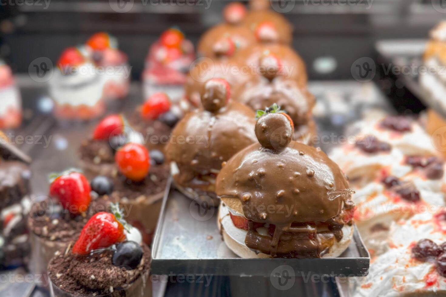 Close-up photo of a glass counter in a bakery or pastry shop with sweets, sponge cakes and chocolate cakes.