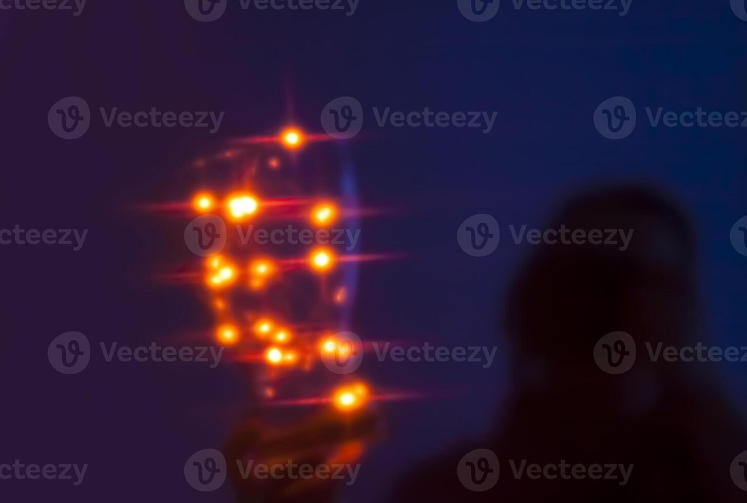 Human unrecognizable silhouette with shiny lights in a dark room photo