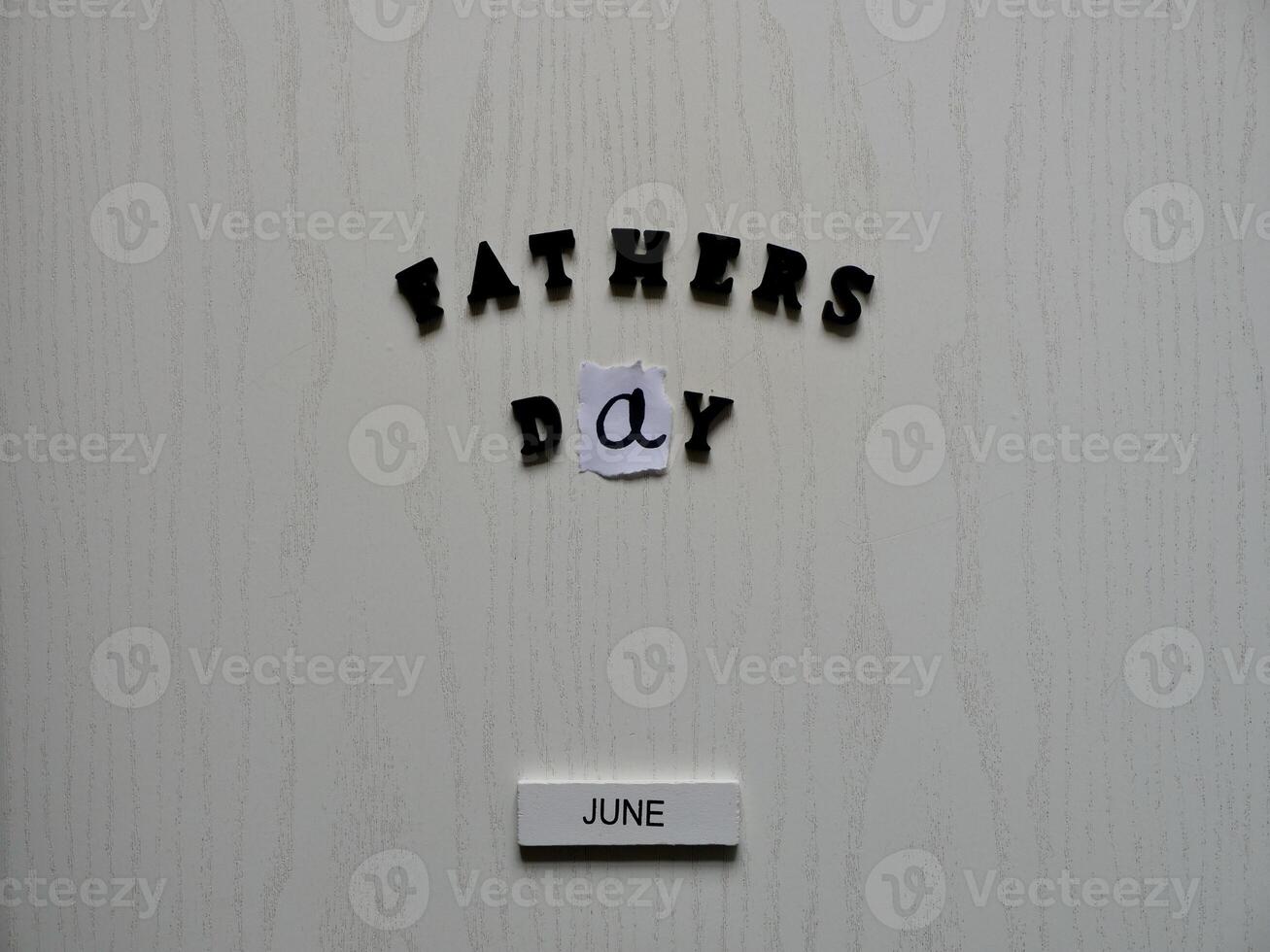 Lettering father in black letters on grey background on father's day close-up photo
