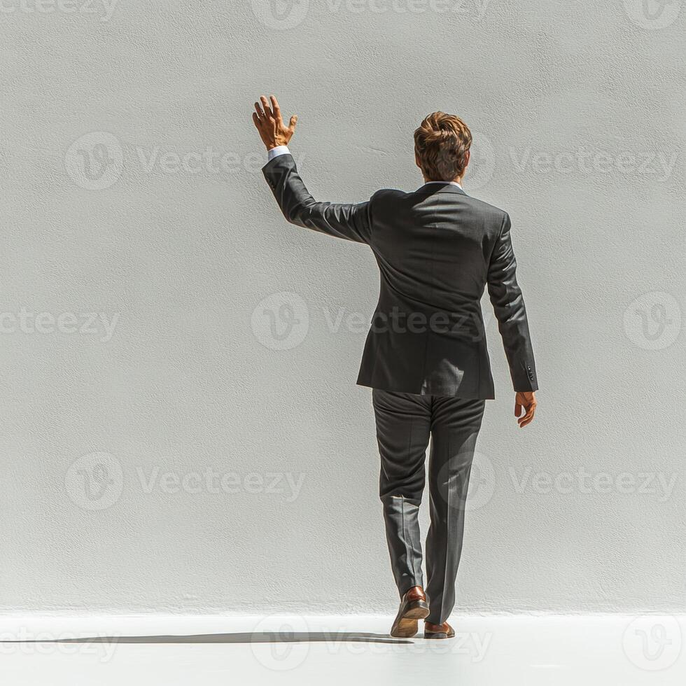 Businessman in suit waving goodbye, showcasing confidence and professionalism. clean background emphasizes subject posture and attire photo