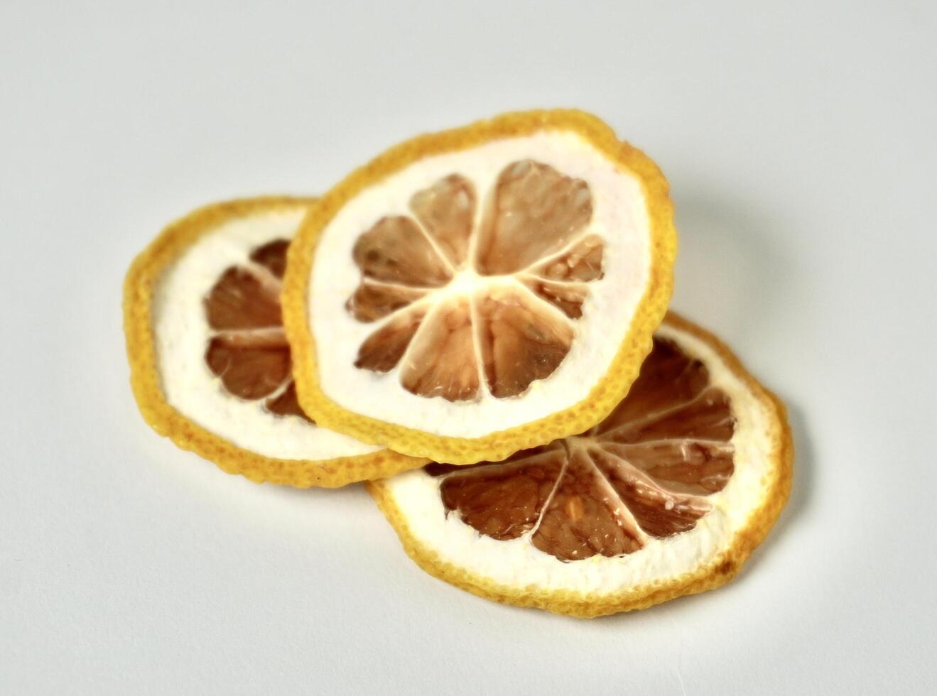 Three dry lemon citrus slices decoration isolated on horizontal white background. photo