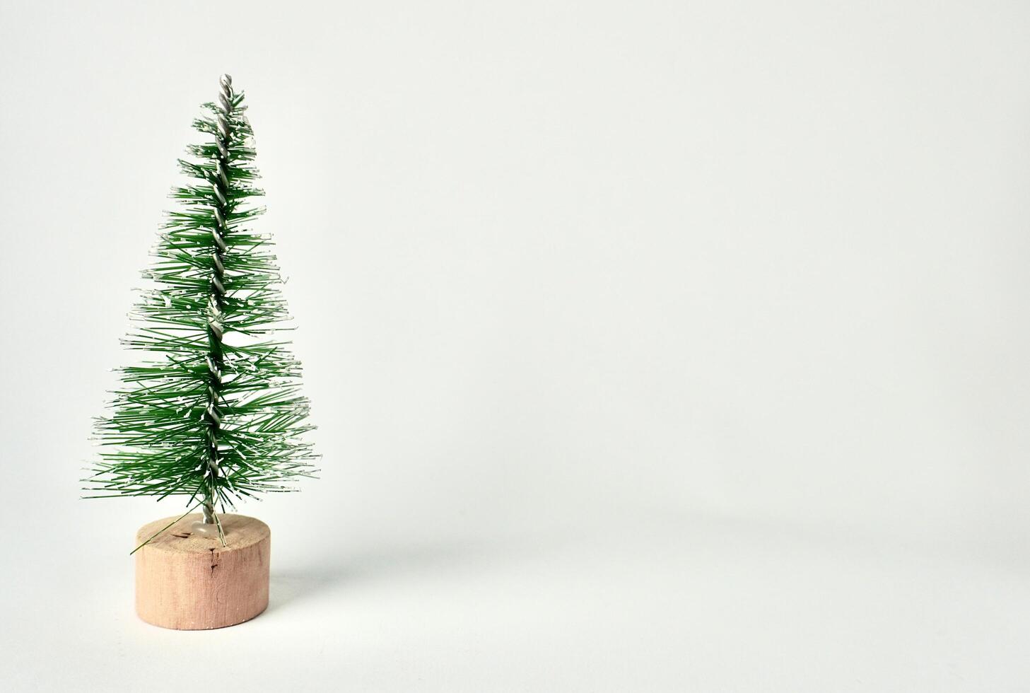 One small green Christmas tree winter decoration display object photography isolated on horizontal copy spaced white background. photo