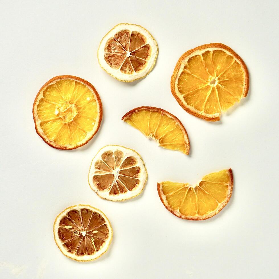 Dried brown yellow lemon and orange fruit slices with different shapes isolated on white background from above angle view. photo