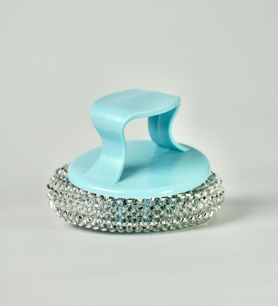 Round metal steel rough scrubber sponge object tool with blue handle isolated on vertical plain background. photo