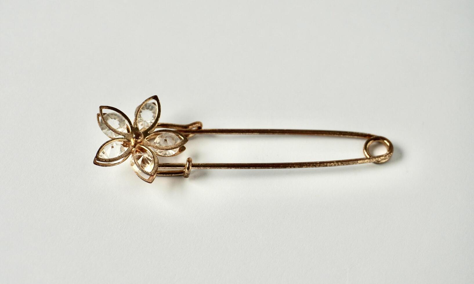 One rusty metal brooch with flower shape design isolated on horizontal white background. photo