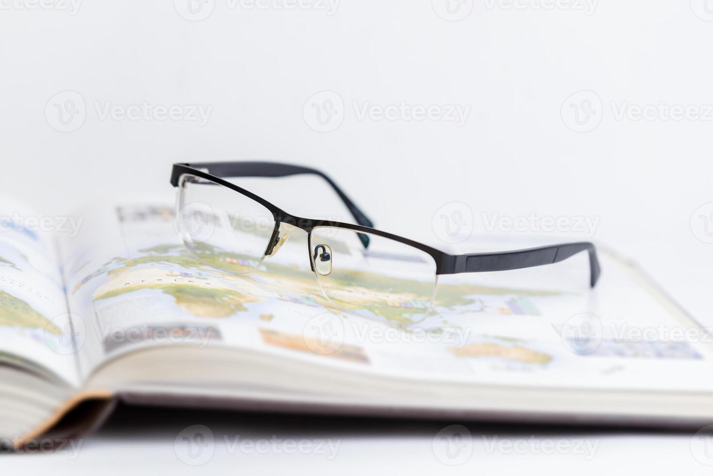 Glasses resting on open book, symbolizing relaxation after intense research and study. Ideal for concepts of learning, focus, academic work, and intellectual breaks photo