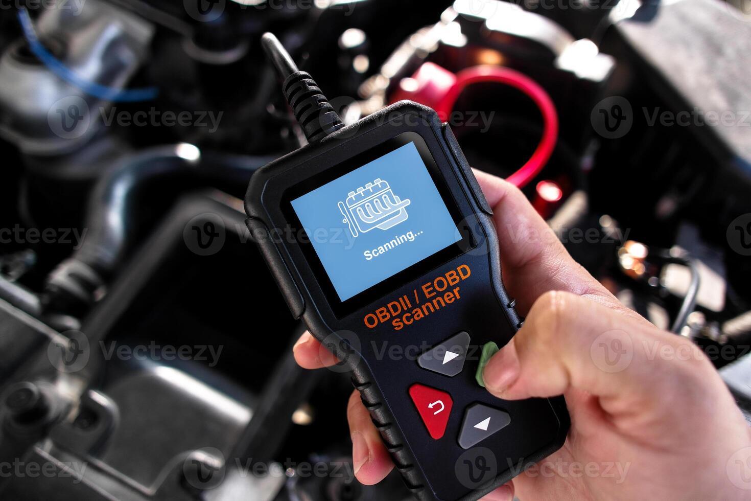 OBDII Scanner in use under the hood by auto mechanic for reading fault code of the car engine system , Car repair concept photo