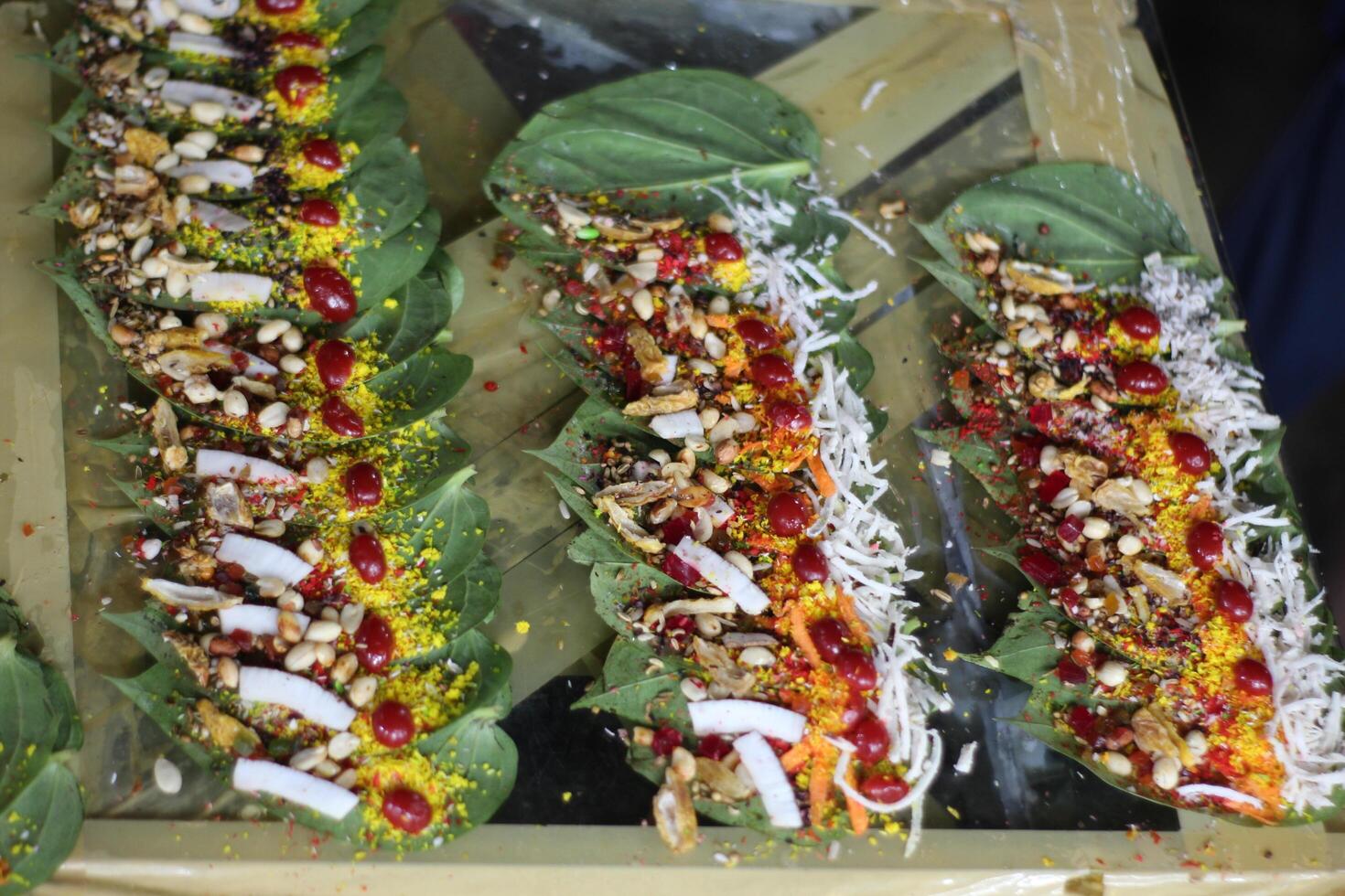 Banarasi paan or betel leaf garnished with betel nut and all indian colorful banarasi ingredients for sale at pous fair,santiniketan photo
