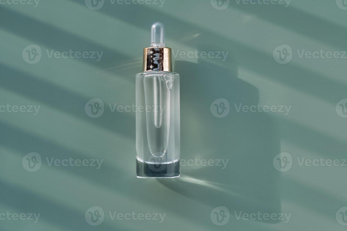 Bottle of cosmetic serum with pipette on green background with shadow stripes. photo