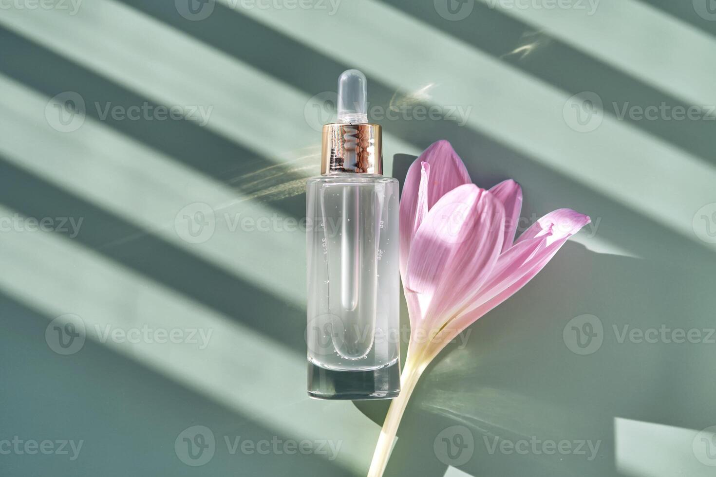 Bottle of cosmetic serum with pipette on green background with shadow stripes. photo